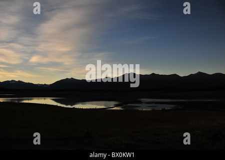 Sonnenuntergang Silhouette der Andengipfel reflektiert in den Gewässern des Lago Roca, mit weit entfernten Pferd Gaucho, Anden, Argentinien Stockfoto