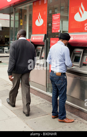 Ein Sikh Jüngling mit Santander Bank ATM Geldautomat im Zentrum von London. DAVID MANSELL Stockfoto