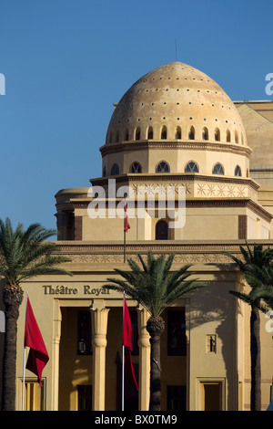 Außenansicht des Théâtre Royal Marrakesch in Marrakesch, Marokko, mit Palmen und marokkanischen Fahnen vor dem Theatergebäude. Stockfoto