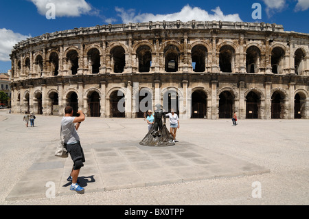 Touristen fotografieren vor dem Roman Amphitheatre, Aromaten oder Arena, Nimes, Languedoc-Roussillon, Frankreich Stockfoto