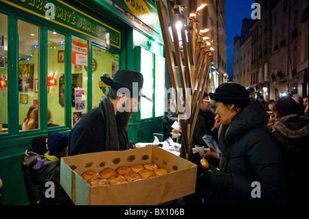 Paris, Frankreich, jüdische Rabbiner feiern jährlichen religiösen Feiertag, Hanukkah, Verteilung von Essen auf der Straße im Marais in der Nacht, alte jüdische Traditionen Stockfoto