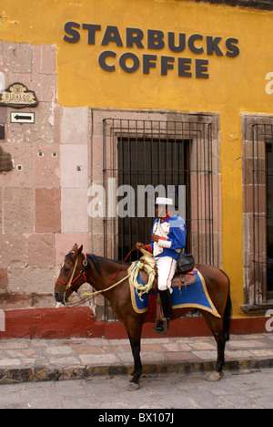 Spanische Polizisten in traditionlal Kostüm auf dem Pferderücken außerhalb der Starbucks Coffee Shop in San Miguel de Allende, Gentrifizierung, amerikanisierung Mexiko. Stockfoto