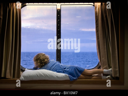 Regnerischen Tag auf See, Kind aus Kreuzfahrt Schiff Fenster Stockfoto