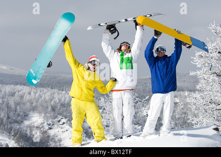 Porträt von drei glückliche junge Snowboarder ihre Arme Stockfoto