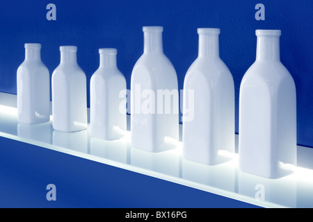 weiße Flaschen hintereinander blau leuchtenden Regal Hintergrunddekoration. Stockfoto