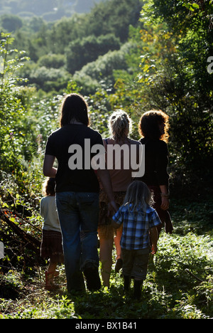 Familiengruppe entlang einen Waldweg am Abend Licht, Wales. Stockfoto