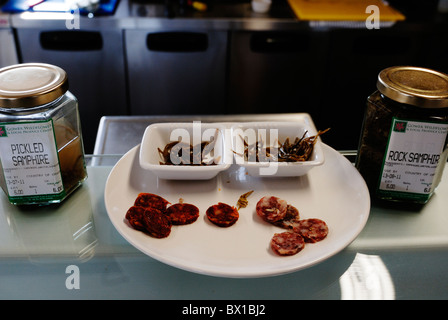 Lokal hergestellte Chorizo-Wurst mit Gläsern von Sammelpflanzen eingelegter Queller zum Verkauf an der Gower Wildflower Centre, Wales. Stockfoto