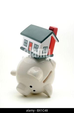 PIGGY BANK BALANCIEREN HAUS AUF RÜCKSEITE RE HAUSHALT HAUSHALT EINSPARUNGEN EIGENTUM CASH LÖHNE ZU HAUSE KÄUFER HYPOTHEKEN MIETEN ETC. UK Stockfoto