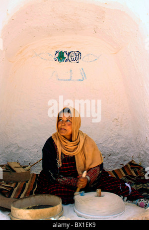 Traditionelle Berber Frau schleift Mais in unterirdischen Wohnung im Matmara Tunesien Modell veröffentlicht Stockfoto