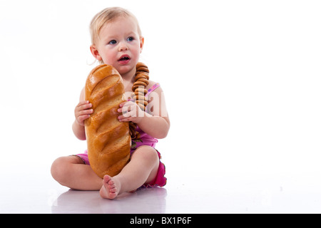 Baby hält einen Laib Brot in Roll Perlen isoliert auf weiss Stockfoto