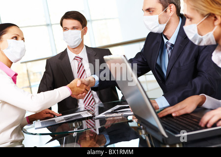 Geschäftspartner in schützende Maske Händeschütteln nach Vertragsunterzeichnung Stockfoto