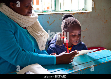 Junges Mädchen und Lehrer am Maji Mazuri Kinderhaus, Nairobi, Kenia Stockfoto