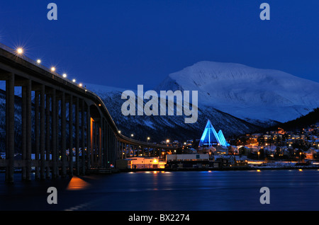 Blaues Licht auf die Eismeerkathedrale in Tromsø, Nordnorwegen. Die Brücke in Tromsø Insel auf der linken Seite. Tromsdalstinden Berg. Stockfoto