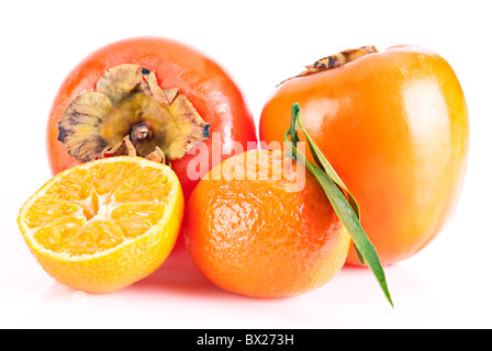 In Orange. Zwei Reife Persimonen und Tangerin mit Blatt über weiß Stockfoto