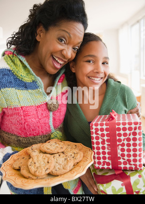 Mutter und Tochter tragen Geburtstagsgeschenk und cookies Stockfoto