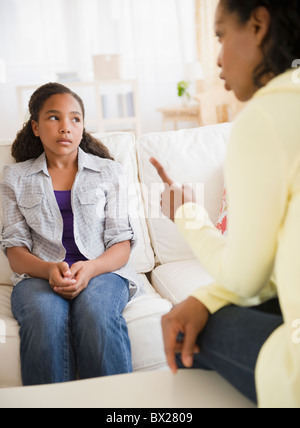 Mutter Vorträge Tochter im Wohnzimmer Stockfoto