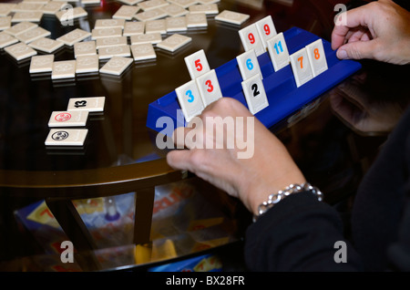 Die Hände der Frau werden gezeigt, wie Sie spielt ein Spiel namens Rummikub. USA. Stockfoto