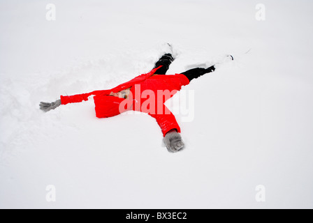 Mädchen mit roten Jacke laufen im Schnee Stockfoto