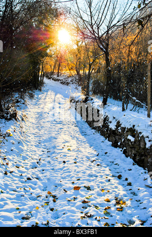 Sonnenuntergang mit Sonne im verschneiten Bergstraße Stockfoto