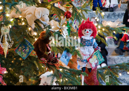 Bücher, Puppen, Stofftiere, glänzende Verzierungen und Lichter schmücken die Kinder Weihnachtsbaum in der Olympia-Capitol Gebäude. Stockfoto