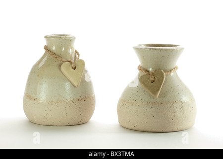 Zwei steinerne Herzen an Schnur gewickelt um zwei Keramik Töpfe Stockfoto