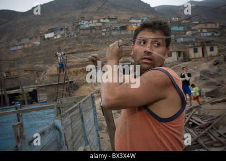 Männer reparieren verworrene Elektroleitungen in San Juan de Miraflores, Lima, Peru. Stockfoto