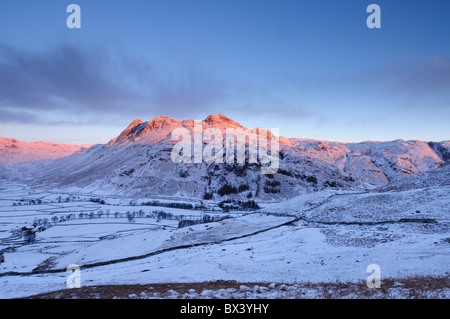 Dawn Winter rosa Sonnenlicht auf den Langdale Pikes im englischen Lake District Stockfoto