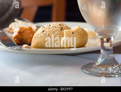 Übrig gebliebene Brot auf einem fertigen Teller mit Essen mit Wasserglas Stockfoto