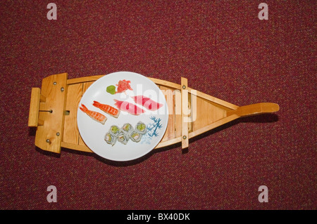 Holz- fach in Form von Boot und weißer Teller mit Sushi und Sashimi, Osaka Sushi Restaurant, Philadelphia, PA, USA Stockfoto