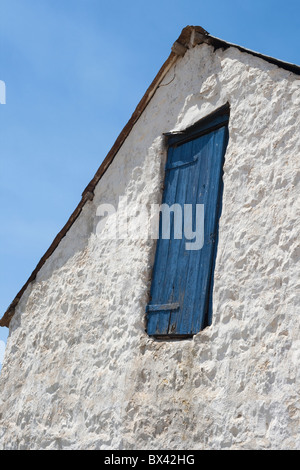 Altes Bauernhaus-Stil mit einer blauen Tür vor blauem Himmel Stockfoto