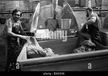Asiatische Fabrik muslimische Männer Fabrikarbeiter Blackburn Lancashire. Menschen, die in kleinen Färbereien arbeiten, sind neue Einwanderer nach Großbritannien. 1983 1980S HOMER SYKES Stockfoto