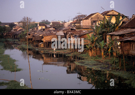 Häuser auf Stelzen an einem Fluss, Vietnam - in der Abenddämmerung. Stockfoto