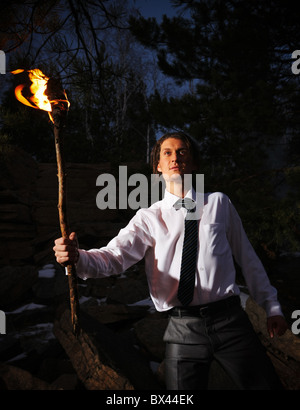 Bild von tapferer Mann mit brennenden Stock in der Dunkelheit Stockfoto