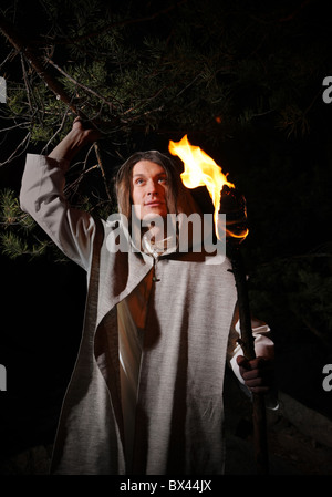 Bild von tapferer Mann mit brennenden Stock in der Dunkelheit Stockfoto