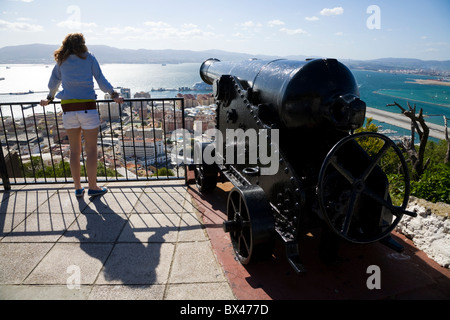 Junges Mädchen / Tourist sieht nach Spanien über Gibraltar Flughafen neben historischen britischen / englischen Kanone Geschütz. Felsen von Gibraltar. Stockfoto