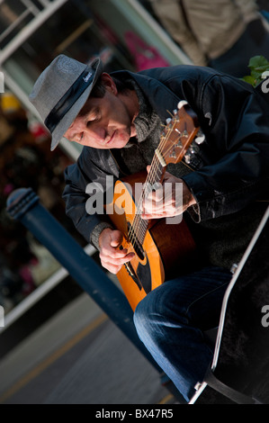 Ein Mann Straßenmusik Gitarre spielen auf der Straße, Aberystwyth Wales UK Stockfoto