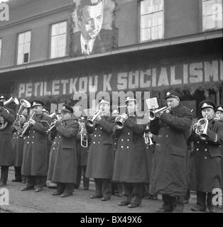 Tschechoslowakei - Prag 1949. Band spielt Volksmusik und riesige Klement Gottwlad Porträt hängt vom Gebäude während der Stockfoto