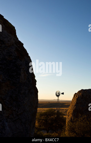 Alte Farm Windmühle inmitten der Silhouette Felsformationen im City of Rocks State Park in New Mexico, USA. Stockfoto