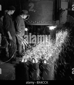 Tschechoslowakei - die meisten, 1950. Eisen Arbeiter füllen Sie Barren Formen mit geschmolzenem Stahl im Stahlwerk. CTK Vintage Photo Stockfoto