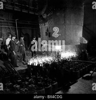 Tschechoslowakei - die meisten, 1950. Eisen Arbeiter füllen Sie Barren Formen mit geschmolzenem Stahl auf Stahl Gießerei. CTK Vintage Photo Stockfoto