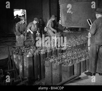 Tschechoslowakei - die meisten, 1950. Eisen Arbeiter füllen Sie Barren Formen mit geschmolzenem Stahl im Stahlwerk. CTK Vintage Photo Stockfoto