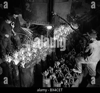 Tschechoslowakei - die meisten, 1950. Eisen Arbeiter füllen Sie Barren Formen mit geschmolzenem Stahl auf Stahl Gießerei. CTK Vintage Photo Stockfoto