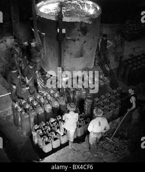 Tschechoslowakei - die meisten, 1950. Eisen Arbeiter füllen Sie Barren Formen mit geschmolzenem Stahl auf Stahl Gießerei. CTK Vintage Photo Stockfoto