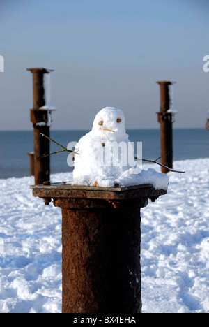 Schneemann auf Resten der West Pier nach seltenen Schneefall am Strand von Brighton, UK Stockfoto