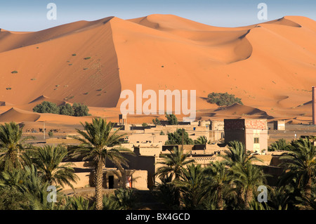 Haus, umgeben von Palmen mit Sanddünen Hintergrund. Stockfoto