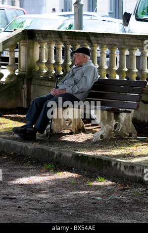Senioren, die auf einer Bank sitzend Stockfoto