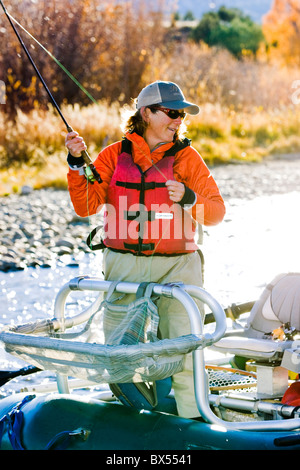 Frau Fliegenfischen vom Boot auf dem Arkansas River, in der Nähe von Salida, Colorado, USA Stockfoto