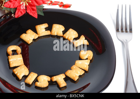 Schwarze Platte mit Charakter geformt Cookies, Gabel und Weihnachten Dekoration isoliert auf weiss Stockfoto