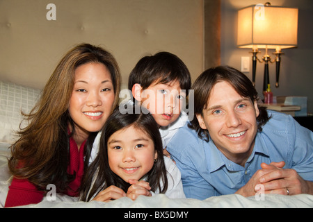 Gemischte Rassen Familie kuscheln im Bett Stockfoto