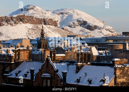 Blick über alte Edinburgh von Castle Esplanade, Aurthurs Sitz, tief verschneit in der Morgensonne Stockfoto